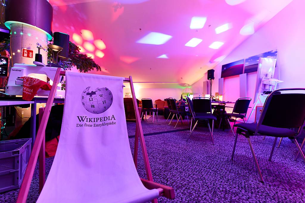 Free Knowledge Habitat auf dem 39C3, in dem sich alles um freies Wissen dreht. Links ist unsere Stickmaschine zu sehen. Foto: Leonhard Lenz, Free Knowledge Habitat at 39C3 2025-12-28 19, CC BY 4.0